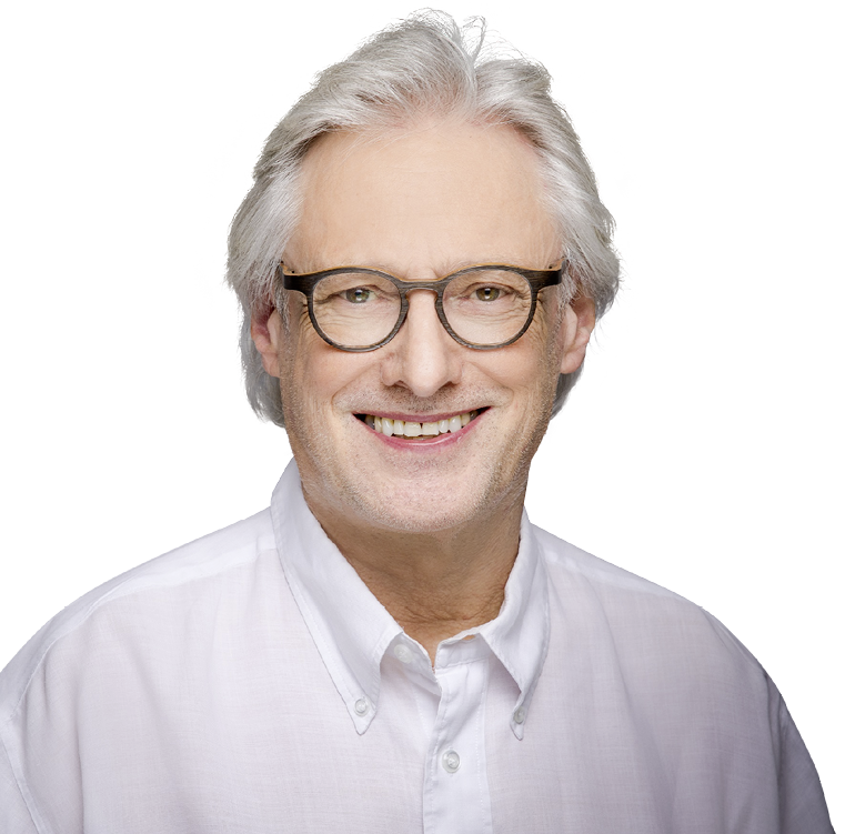 Eine l chelnde Person mit grauen Haaren, Brille und wei em Hemd vor wei em Hintergrund. Beschreibung von KI generiert